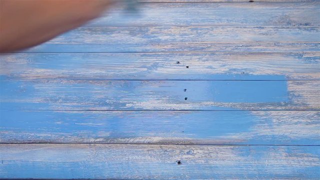 An accelerated footage of a wooden board being painted in blue