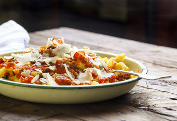 Italian pasta with tomato sauce, smoked pancetta, roasted almonds and parmesan cheese