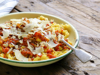 Italian pasta with tomato sauce, smoked pancetta, roasted almonds and parmesan cheese