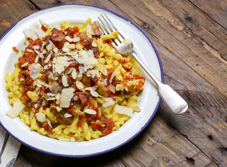 Italian pasta with tomato sauce, smoked pancetta, roasted almonds and parmesan cheese