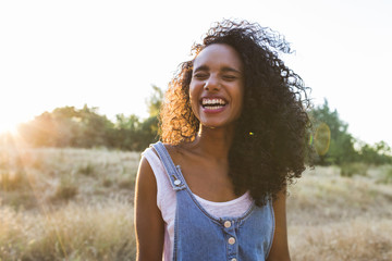 portrait outdoors of a young afro american woman. Yellow background. Lifestyle