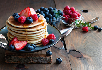  Pancakes with fresh berries and maple syrup for breakfast, selective focus, toned image