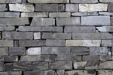 Blue gray purple slate wall, pointed. Textured background landscape orientation. Old Slate stone wall.