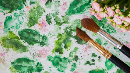 Abstract art hand watercolor and brushes, floral background. Romantic concept of spring, lifestyle, hobbies. Top view. With place for your text, for backdrop, substrate, composition use.