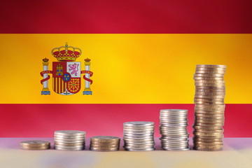 Symbol of inflation and diagram of coins with the against of the Spain flag