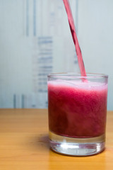 pouring red wine into a glass of liquid