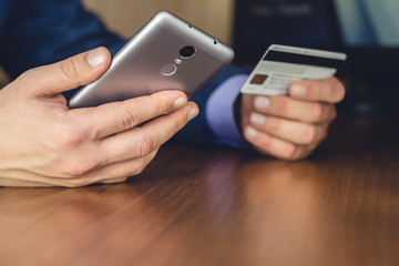 Formal wear, man hands using smartphone and holding credit card for online shopping and payment, selective focus.