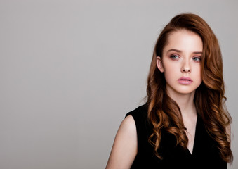 Fototapeta premium Young beautiful fashion model wearing black dress