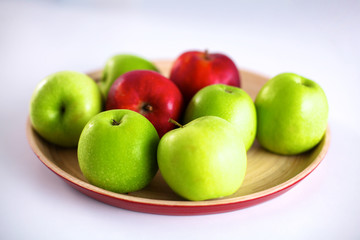 Still life arrangement of apples on a wooden platter
