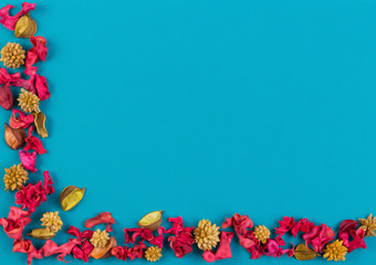 Dried flowers, exotic leaves and plants frame on blue background. Top view, flat lay.