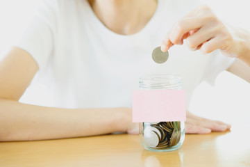 Woman hands with coins in glass jar, close up