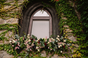 Fototapeta na wymiar Old stone wall with a wedding decorated window