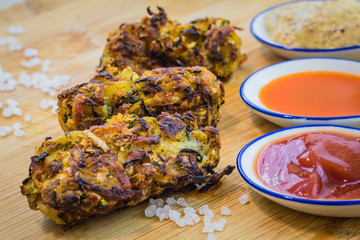 Homemade veggie zucchini tots with condiments in decorative serving spoons and sea salt side view