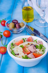 Pasta salad with tuna, olives, cherry tomatoes and arugula