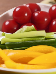 Plate with vegetables yellow pepper, leeks and cherry tomato, leeks in focus,