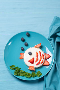 Funny toast in a shape of fish, sandwich with cream cheese and berries, food for kids idea, top view