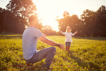 Father with daughter playing ball outdoor