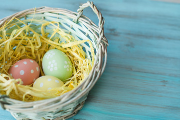 Easter decor, eggs in a basket on a blue, wooden background. Banner, top view