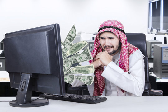 Arabian businessman looks unhappy with a computer