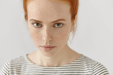 Close-up highly-detailed portrait of amazing young redhead female model with green eyes and clean...