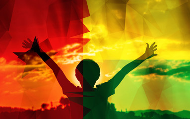 Young man raising his hands on a sunset background with a flag background - 139374294