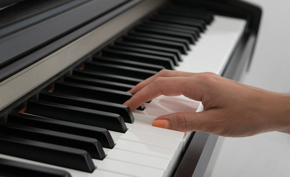 Woman playing the piano, part of hand, learning to play