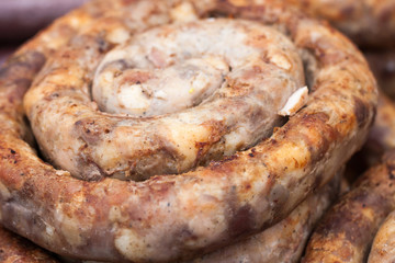 Roasted spiral pork sausages as a background. Selective focus