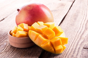 mango and mango slices on a wooden table