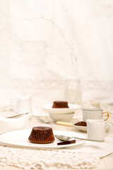 Chocolate french cake mi-cuit on white plate over on white tablecloth