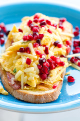 Close up of breakfast dish - omelette with green onion and ham, garnished with pomegranate
