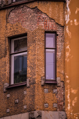 Fototapeta na wymiar Windows in an old house with the broken colorful facade