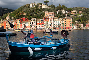 Fototapeta premium Traditional wooden fishing boat moored at port of Portofino town in Liguria district, Italy