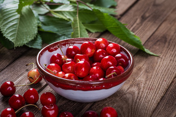 Fresh cherries in bowl on table