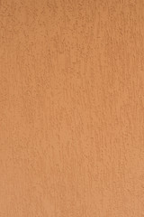 Detail of the facade of the house, wall plastered and painted in color, textured background