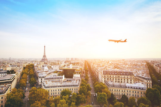 Fototapeta travel to France, airplane flying over beautiful panoramic cityscape of Paris with Eiffel Tower