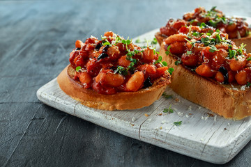 Beans fried in tomato sauce on toasted bread with cross salad sprinkle