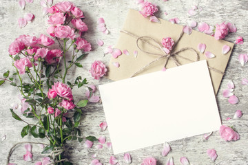 Obraz premium Blank white greeting card and envelope with pink rose flowers
