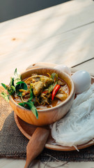 Vintage Thai traditional food style Thai vermicelli eaten with green curry chicken hot and spicy(Kanom jean keawwhan kai) on wooden background wallpaper focus one point shallow with depth of field