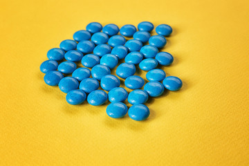 Tasty blue candies on color background