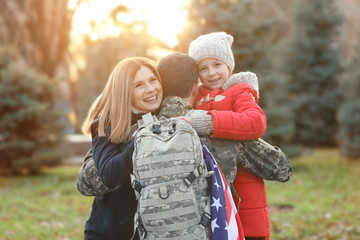 USA soldier hugging his family outdoors