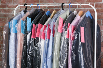 Rack of clean clothes hanging on hangers at dry-cleaning