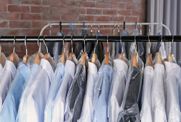 Rack of clean clothes hanging on hangers at dry-cleaning