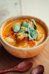 Vintage style Thai traditional food style spicy muslim curry (Massaman chicken curry) on wooden background wallpaper focus one point shallow with depth of field