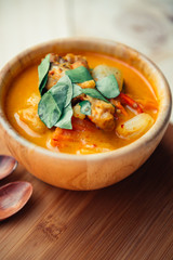 Vintage style Thai traditional food style spicy muslim curry (Massaman chicken curry) on wooden background wallpaper focus one point shallow with depth of field
