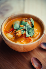 Vintage style Thai traditional food style spicy muslim curry (Massaman chicken curry) on wooden background wallpaper focus one point shallow with depth of field