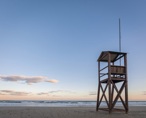 Beach sunrise with lifeguard wood tower