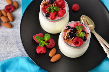Vanilla yogurt with berries on a concrete background.
