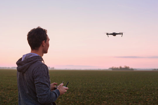 Man Piloting Drone At Sunset Outdoors