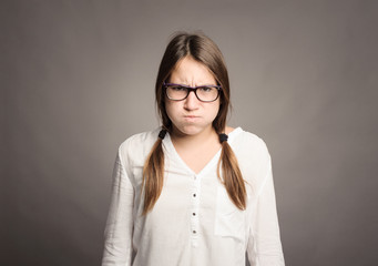 portrait of angry young girl on gray background