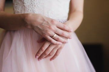 Bride's hands on beautiful white wedding dress.